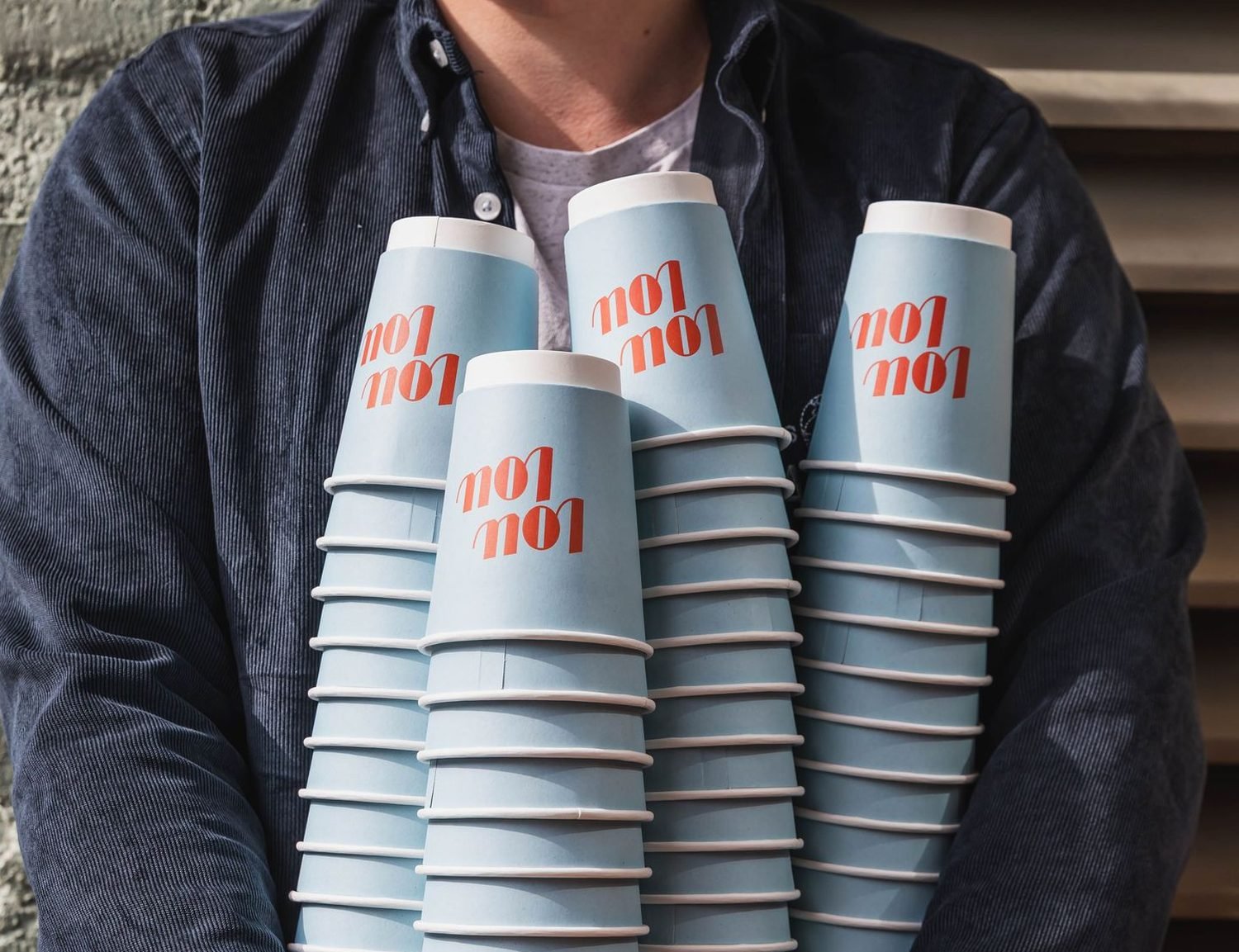 Tall stacks of custom-printed paper cups held in a caf&eacute; doorway