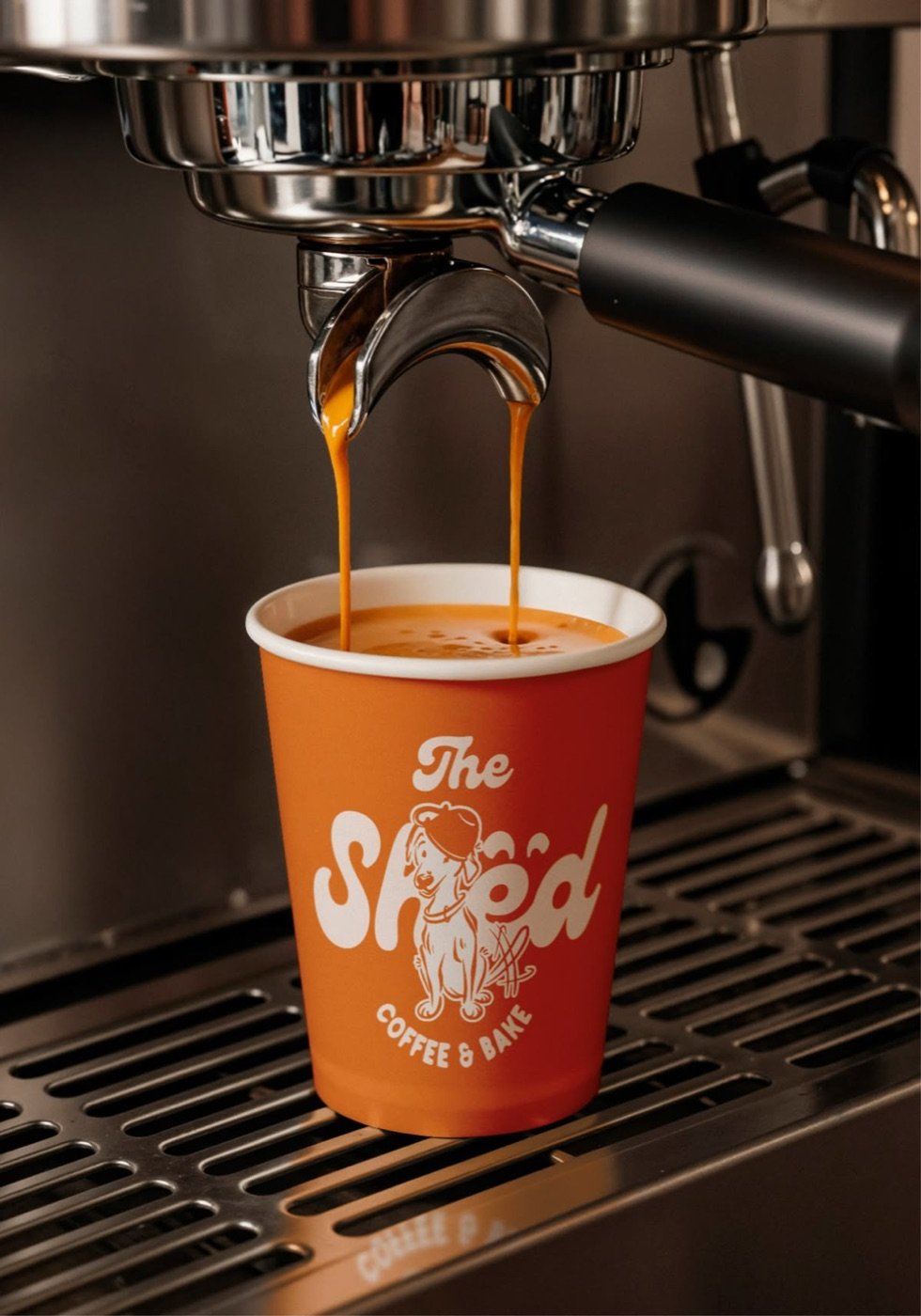 Espresso pouring into a custom-printed paper cup